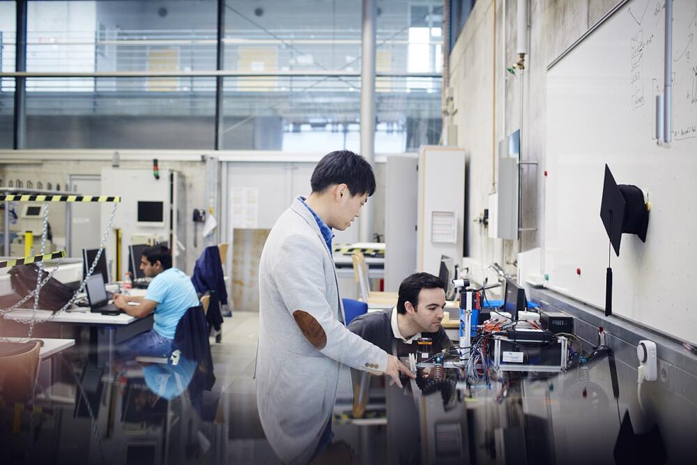 Research team working in laboratory. Senior and junior staff are looking at equipment