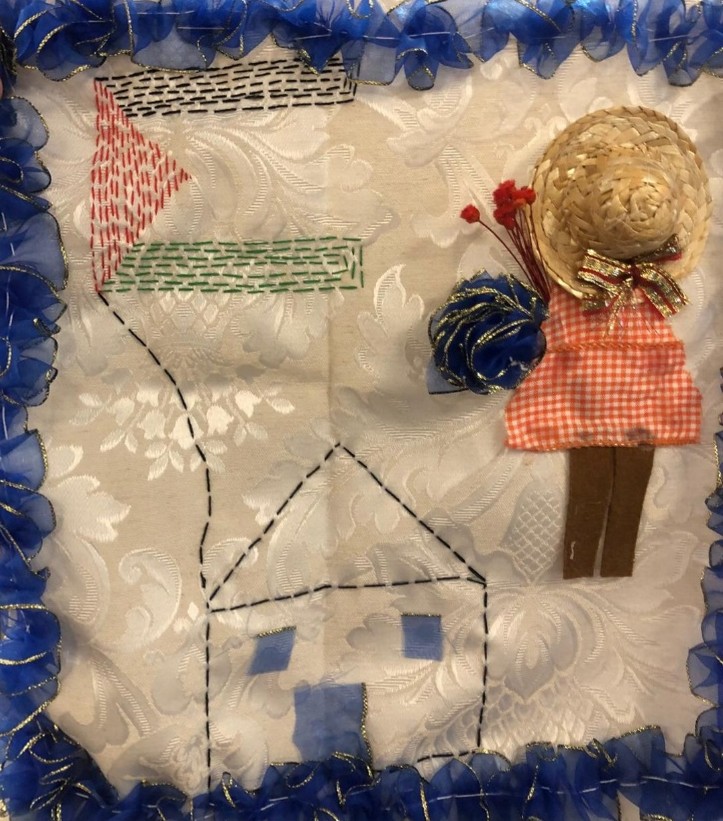 Figure 3 - Quilt panel depicting a house with a Palestinian flag, and a girl standing alongside it.